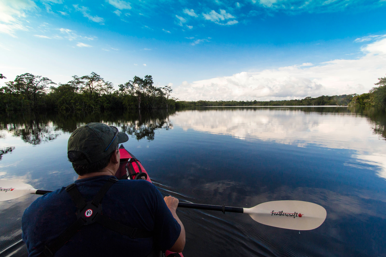 Kayaker on beautiful mirror calm Amazon lake