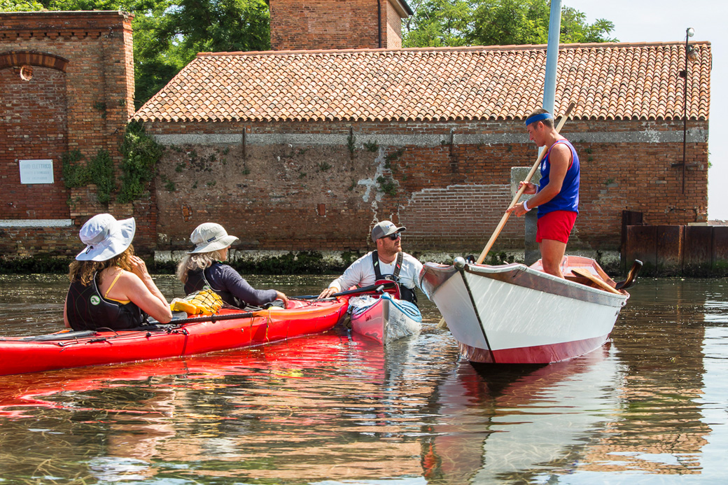 Kayakers meeting a Venetian rower while the kayak Venice.