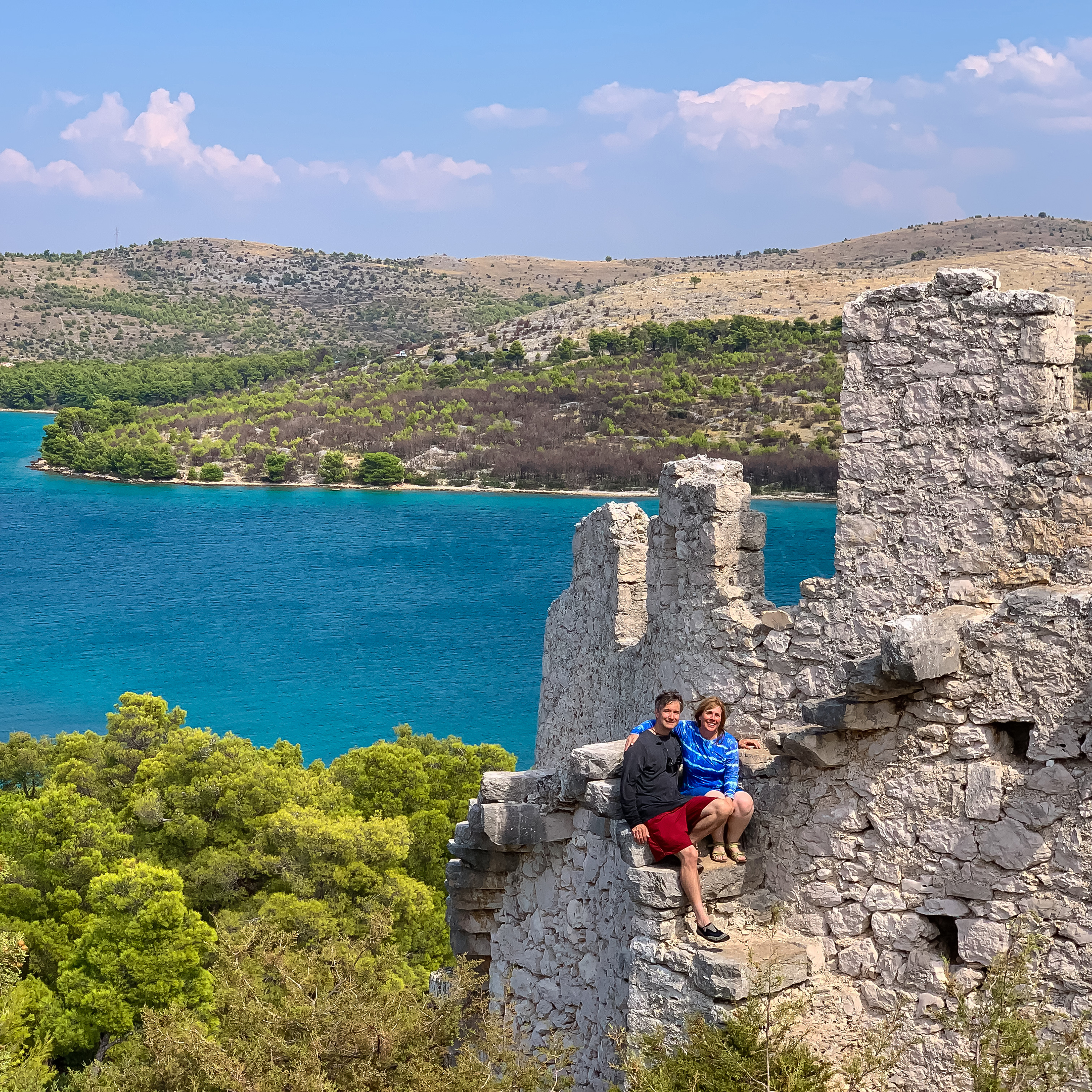 Couple posed on ancient wall, Croatia kayaking tour